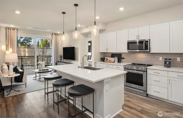 a kitchen with stainless steel appliances a stove a sink and a refrigerator