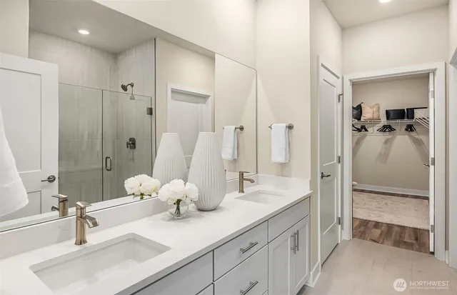 a bathroom with a double vanity sink mirror and shower