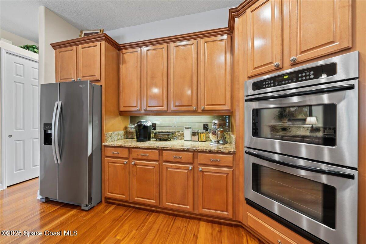 8167 Andover Way Melbourne, FL 32940 - Photo 13 of 78 a kitchen with granite countertop white cabinets and stainless steel appliances