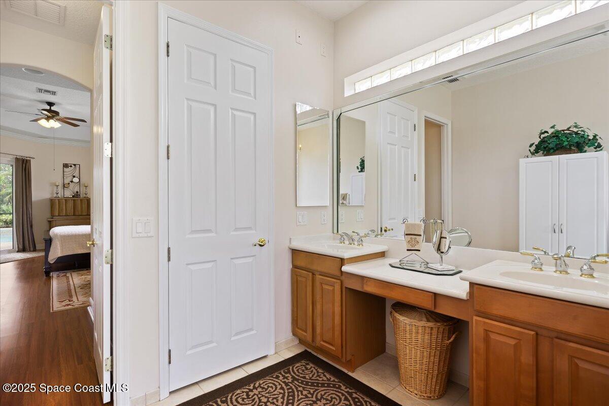 8167 Andover Way Melbourne, FL 32940 - Photo 25 of 78 a bathroom with a double vanity sink and mirror