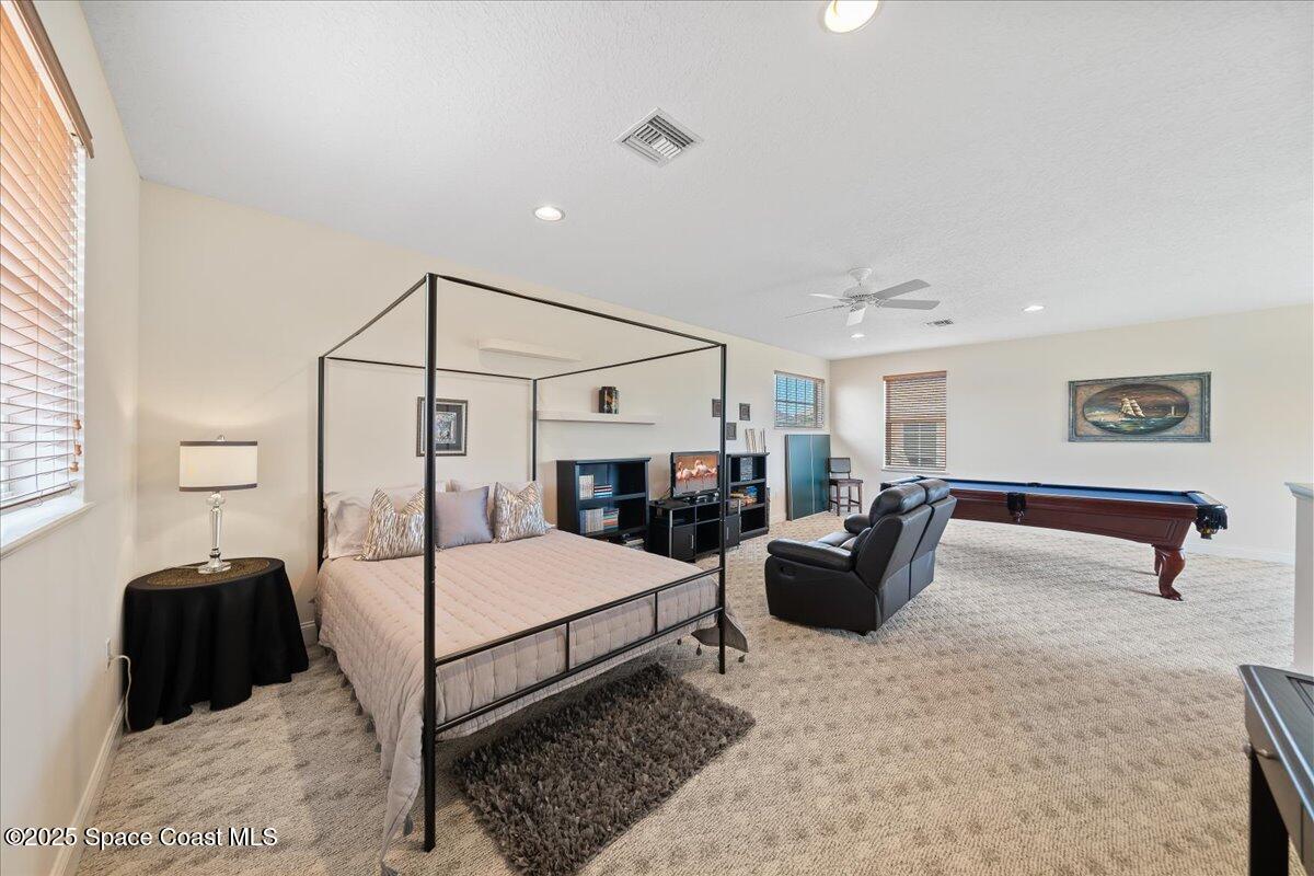 8167 Andover Way Melbourne, FL 32940 - Photo 39 of 78 a bedroom with a bed couch and a window