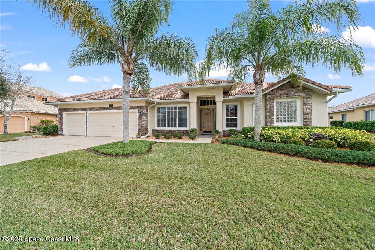 8167 Andover Way Melbourne, FL 32940 - Photo 56 of 78 a front view of a house with a garden and palm trees
