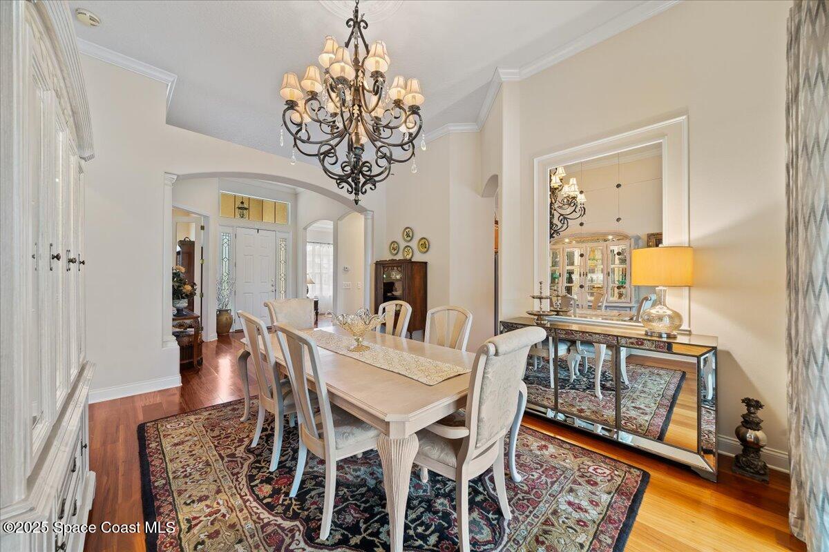 8167 Andover Way Melbourne, FL 32940 - Photo 7 of 78 a view of a dining room with furniture a chandelier and wooden floor