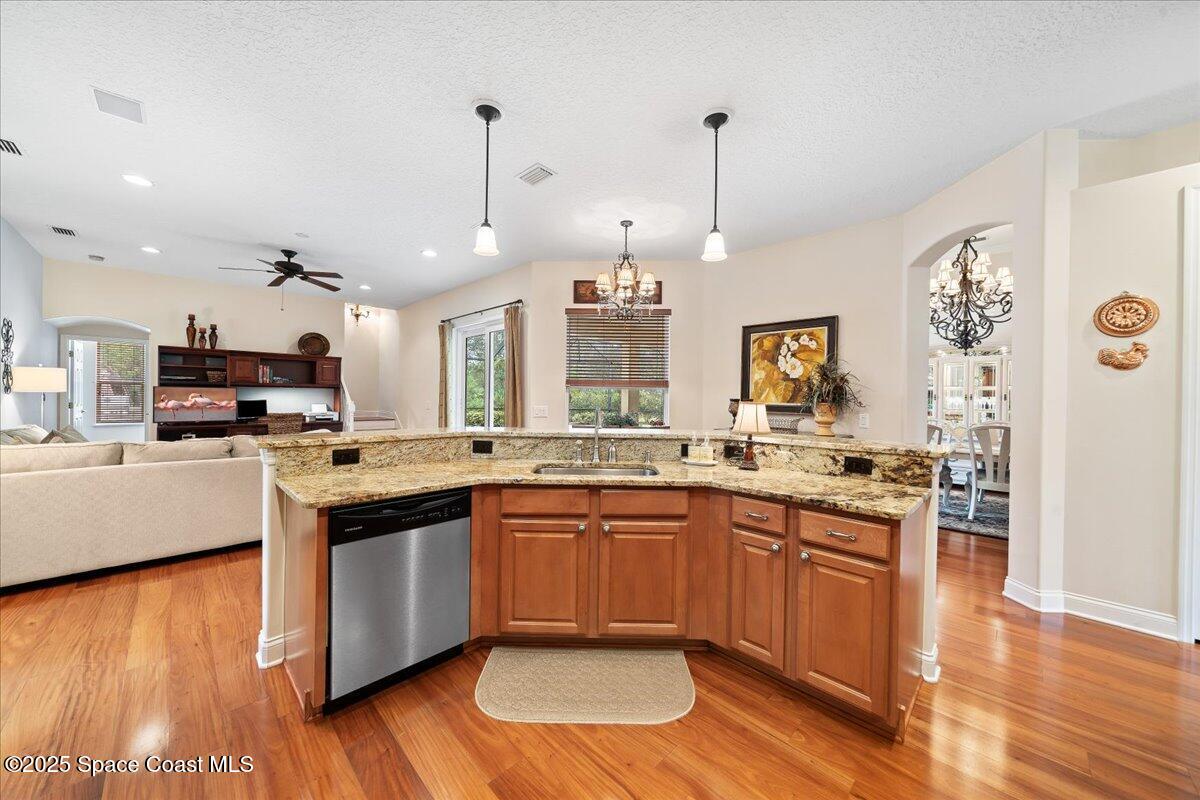 8167 Andover Way Melbourne, FL 32940 - Photo 10 of 78 a kitchen with stainless steel appliances granite countertop wooden floors and view living room