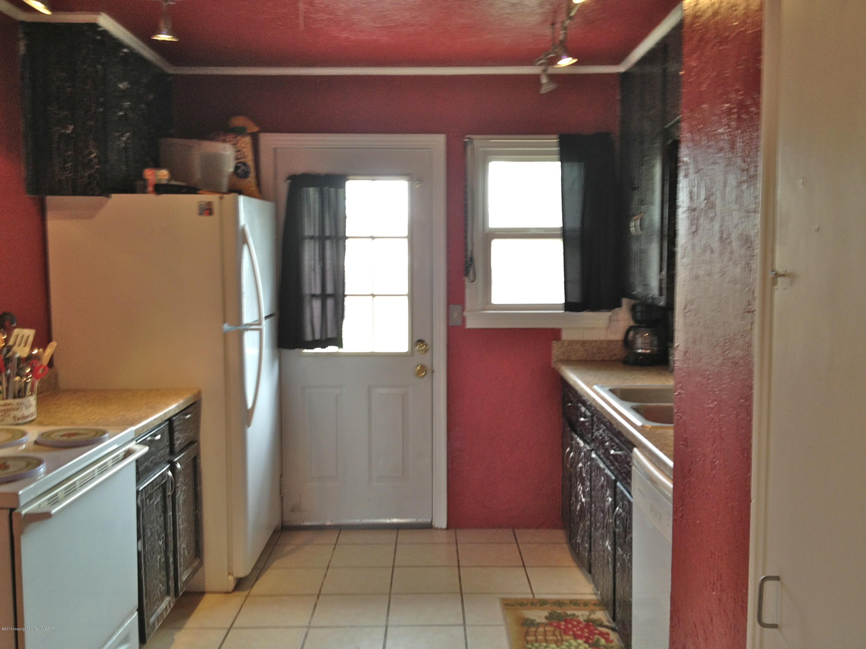 4305 South Lipscomb Street Amarillo, TX 79110 - Photo 3 of 18 a kitchen with a refrigerator a stove top oven and cabinets