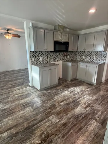 a large kitchen with kitchen island granite countertop a sink and a stove top oven