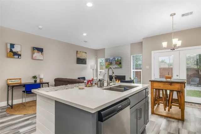 a view of center island dining table chairs and white cabinets
