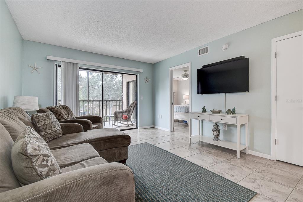 12900 Vonn Road, Unit C202 Largo, FL 33774 - Photo 16 of 38 a living room with furniture and a flat screen tv