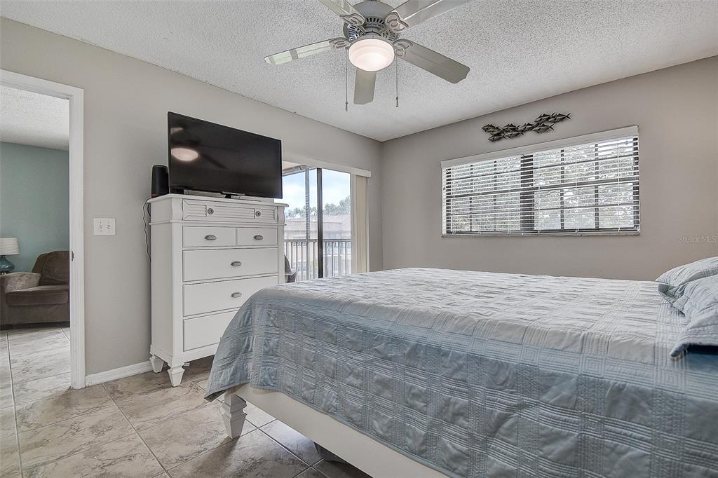 12900 Vonn Road, Unit C202 Largo, FL 33774 - Photo 17 of 38 a bedroom with a bed flat screen tv and a window