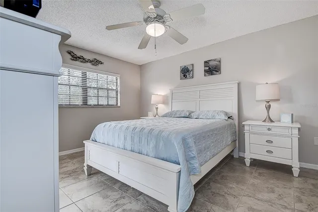 a spacious bedroom with a bed and a chandelier
