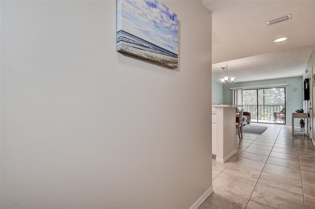 12900 Vonn Road, Unit C202 Largo, FL 33774 - Photo 4 of 38 a hallway with a dining table and chairs