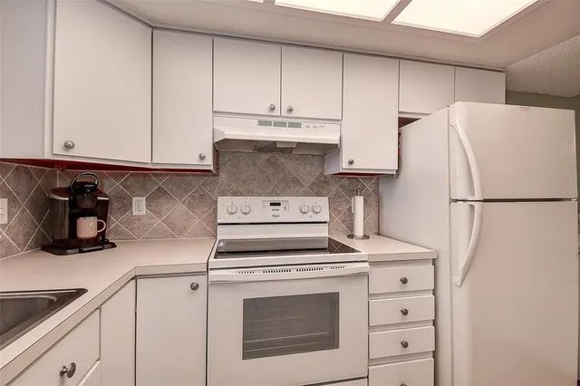 a kitchen with cabinets appliances and a sink