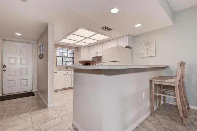 a kitchen with kitchen island a counter top space appliances and a cabinets