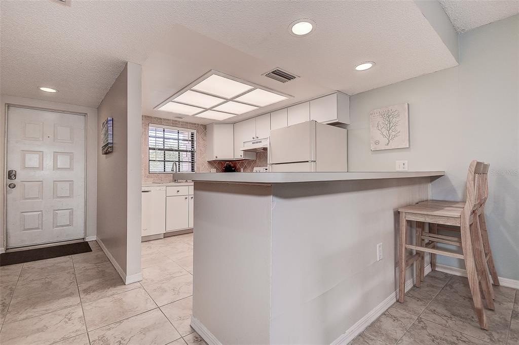 12900 Vonn Road, Unit C202 Largo, FL 33774 - Photo 10 of 38 a kitchen with kitchen island a counter top space appliances and a cabinets