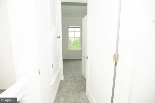 a view of a hallway with white walls and a white wall