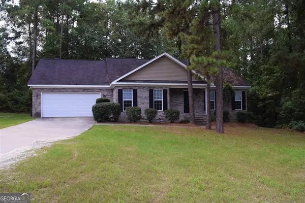 a front view of a house with a garden and trees