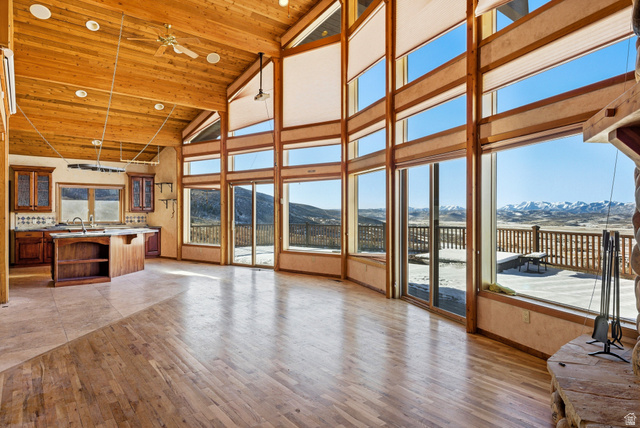 3090 North Rocky Road Kamas, UT 84036 - Photo 5 of 17 Unfurnished living room with high vaulted ceiling, light wood-type flooring, a mountain view, a wooden ceiling with exposed beams, and a ceiling fan