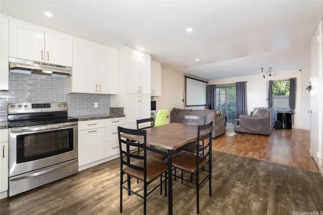 a kitchen with a table chairs stove and cabinets