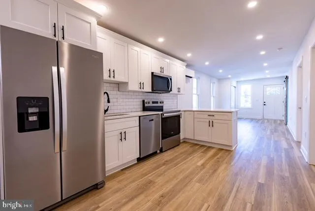 a kitchen with stainless steel appliances a refrigerator and a stove top oven