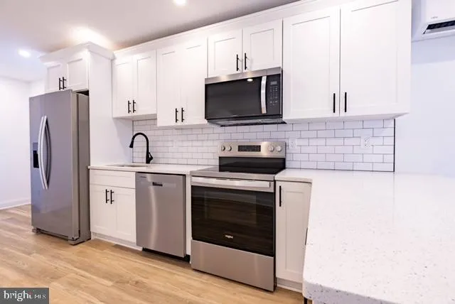 a kitchen with stainless steel appliances a stove microwave and sink
