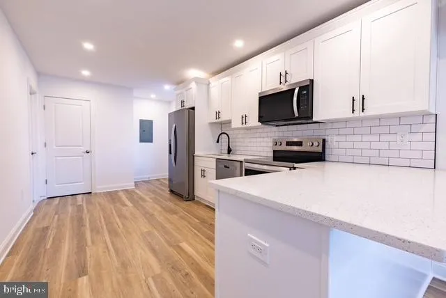 a kitchen with stainless steel appliances a refrigerator sink and microwave