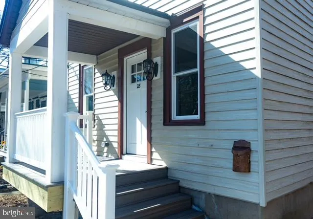 a view of a house with entryway and wooden stairs