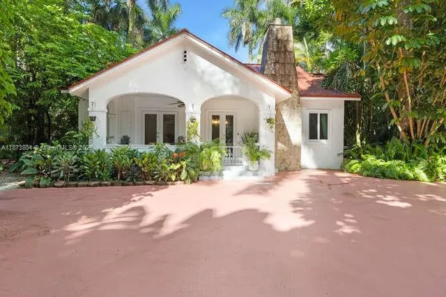 a view of a white house with a yard and large tree