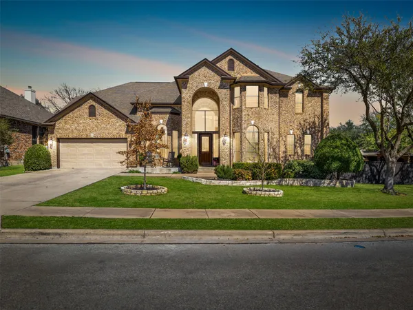 a front view of a house with a yard and a garden