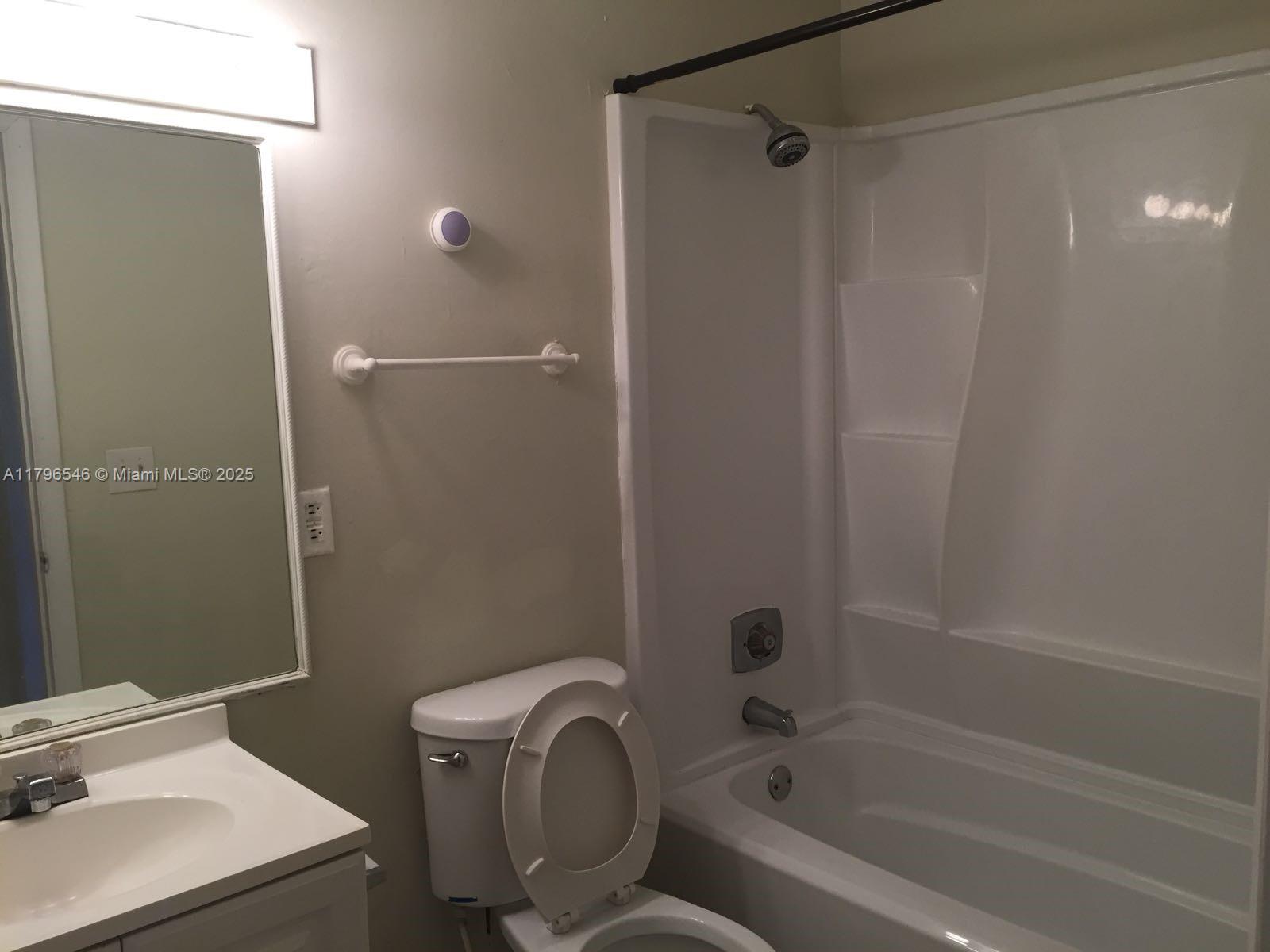 1225 Southwest 46th Avenue, Unit 211 Pompano Beach, FL 33069 - Photo 2 of 2 a bathroom with a sink a toilet and shower