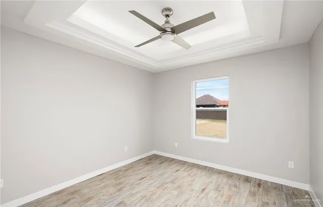 an empty room with a window and a ceiling fan