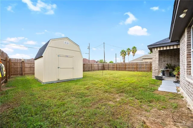 a front view of house with yard and trees in the background