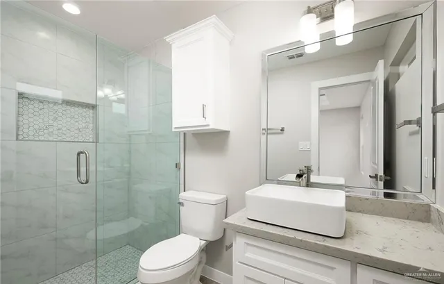 a bathroom with a shower a toilet and a sink