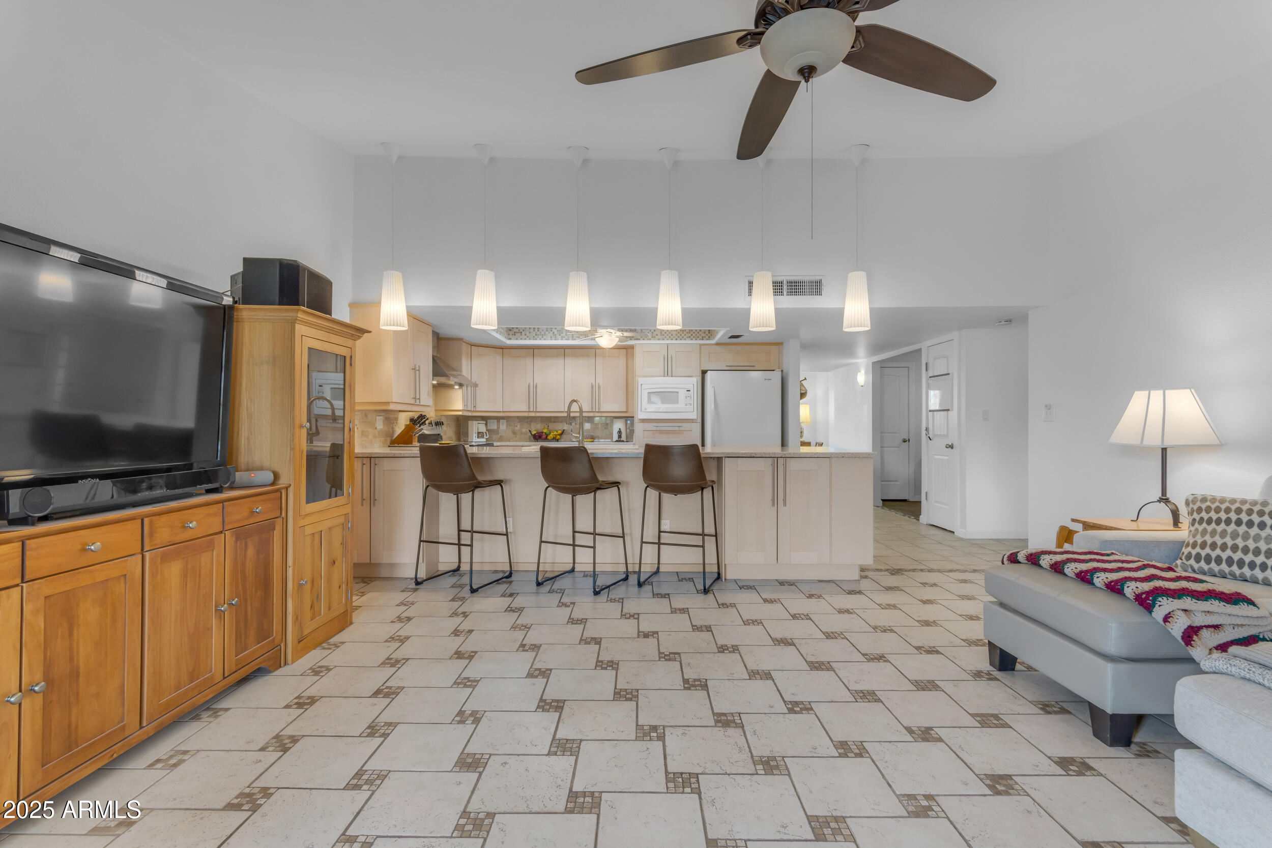 5165 East Tunder Drive Phoenix, AZ 85044 - Photo 14 of 44 a living room with stainless steel appliances kitchen island granite countertop furniture and a flat screen tv