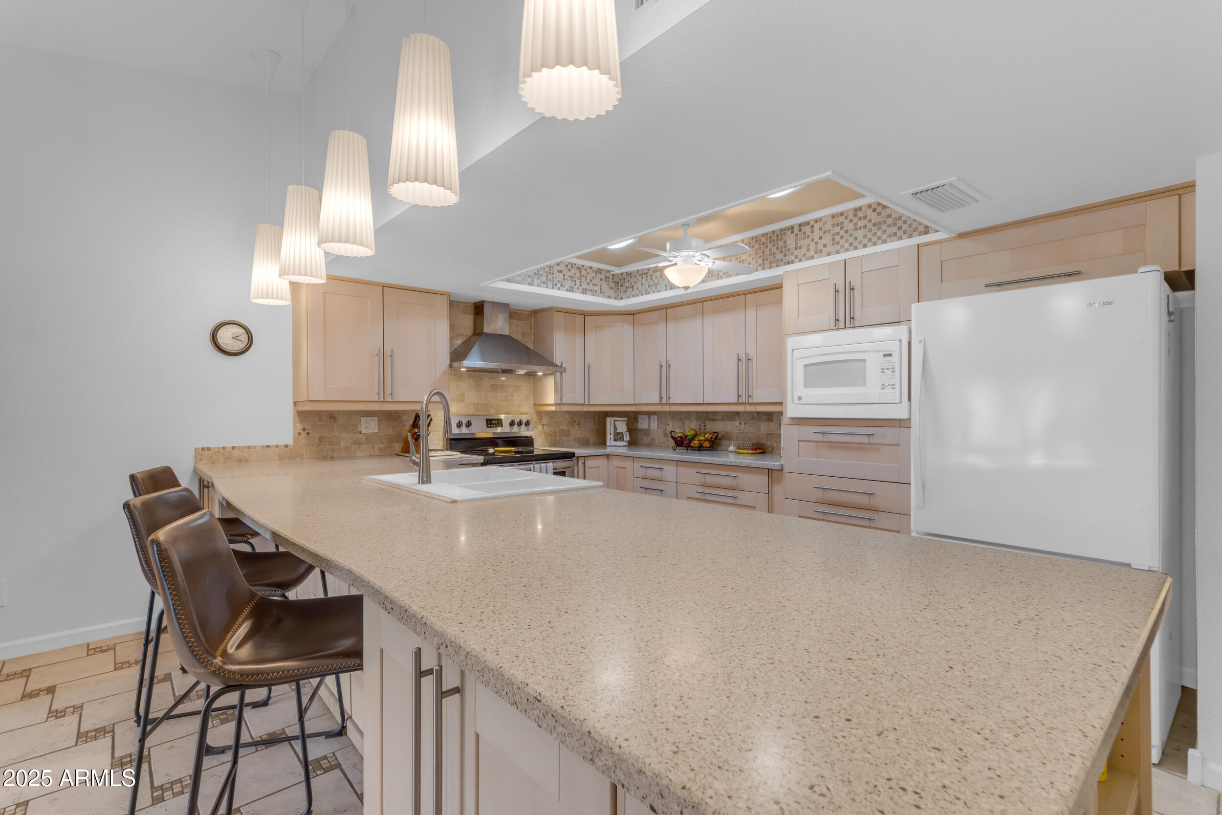 5165 East Tunder Drive Phoenix, AZ 85044 - Photo 6 of 44 a kitchen with stainless steel appliances a table and chairs in it