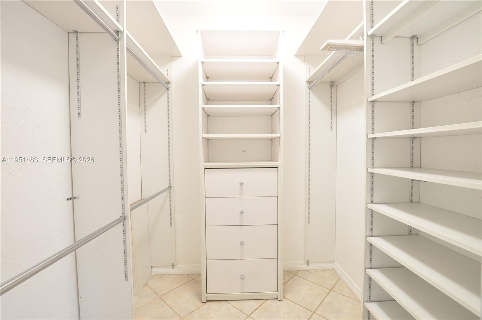 10502 Southwest 77th Court, Unit 10502 Pinecrest, FL 33156 - Photo 22 of 33 a view of walk in closet with empty racks