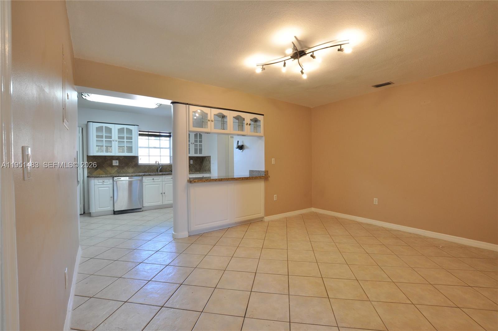 10502 Southwest 77th Court, Unit 10502 Pinecrest, FL 33156 - Photo 6 of 33 a view of a kitchen with furniture and an empty room