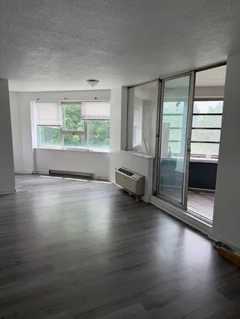 a view of empty room with wooden floor and fireplace
