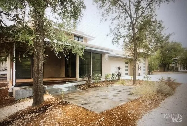 a front view of a house with a yard and trees