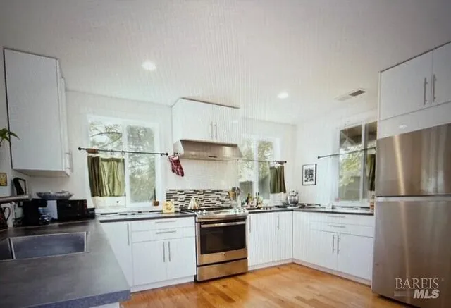 a kitchen with white cabinets and white appliances