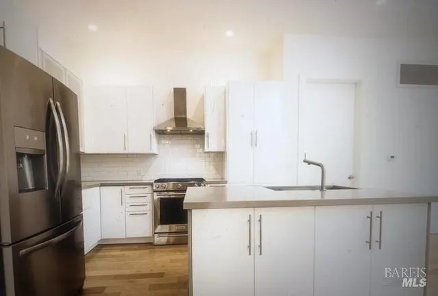 a kitchen with stainless steel appliances granite countertop a refrigerator and a sink