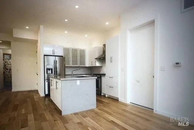 a kitchen with stainless steel appliances a refrigerator and a stove top oven