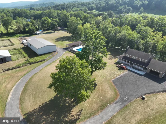 an aerial view of a house with a yard basket ball court and outdoor seating