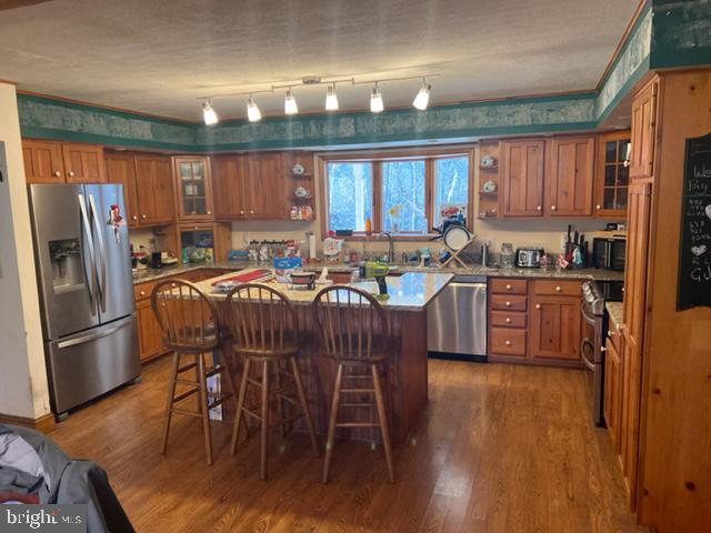 13900 Schellsburg Road Ellerslie, MD 21529 - Photo 35 of 59 a kitchen with stainless steel appliances wooden floors and wooden cabinets