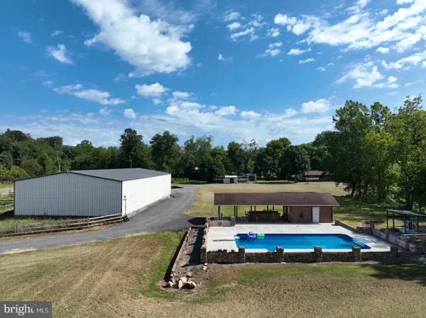 a view of swimming pool with seating area and trees in the background