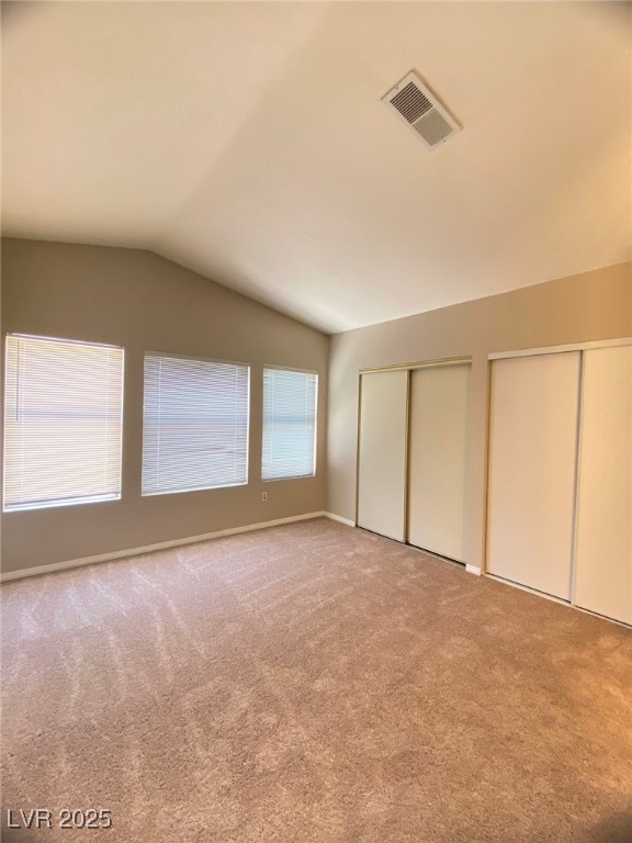 1425 Spice Sky Drive Las Vegas, NV 89128 - Photo 9 of 16 Unfurnished bedroom with two closets, lofted ceiling, and light colored carpet