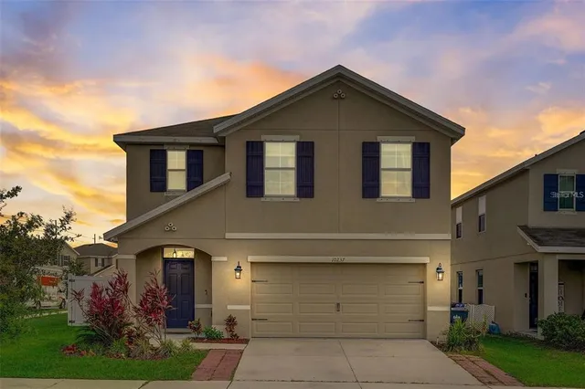 a front view of a house with a yard and garage