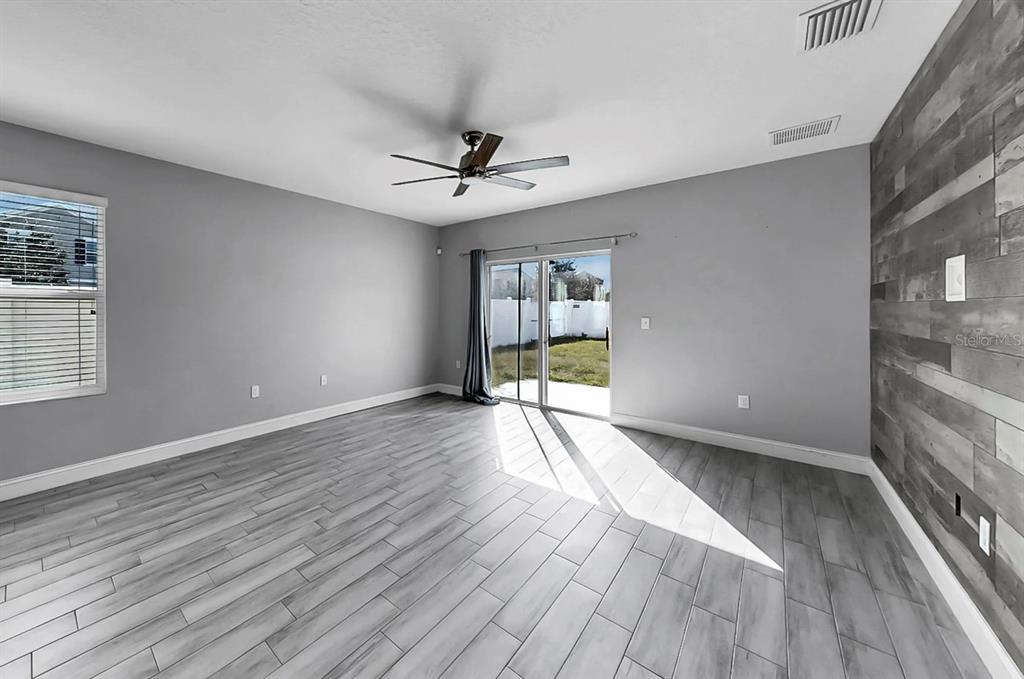 10237 Mangrove Well Road Sun City Center, FL 33573 - Photo 12 of 56 a view of an empty room with a window and wooden floor