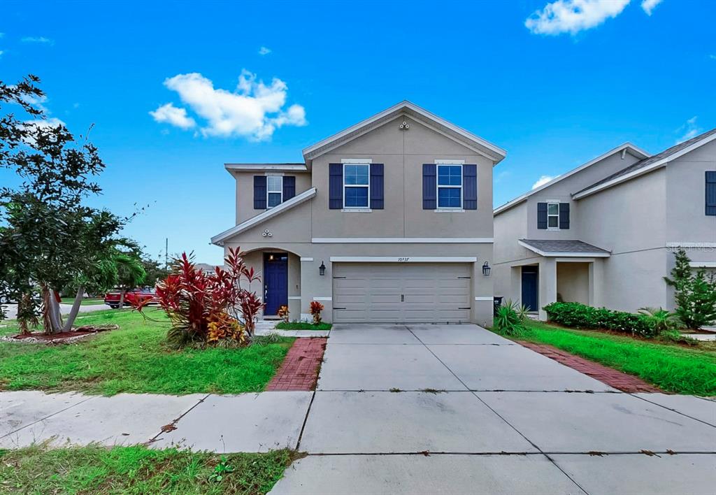 10237 Mangrove Well Road Sun City Center, FL 33573 - Photo 56 of 56 a front view of a house with a yard and a garage