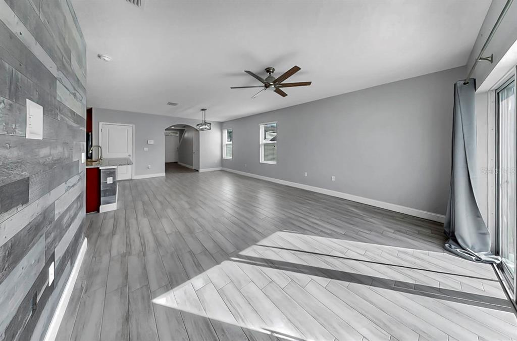 10237 Mangrove Well Road Sun City Center, FL 33573 - Photo 6 of 56 a view of empty room with wooden floor and fan