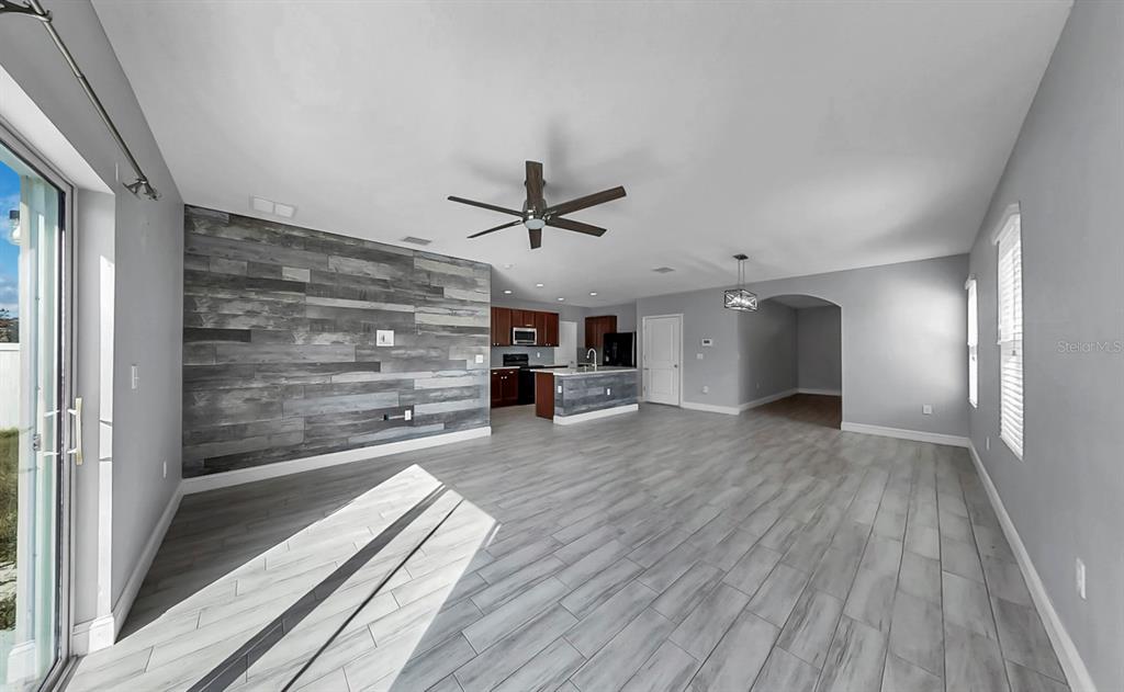 10237 Mangrove Well Road Sun City Center, FL 33573 - Photo 7 of 56 a view of a hallway with wooden floor and a ceiling fan